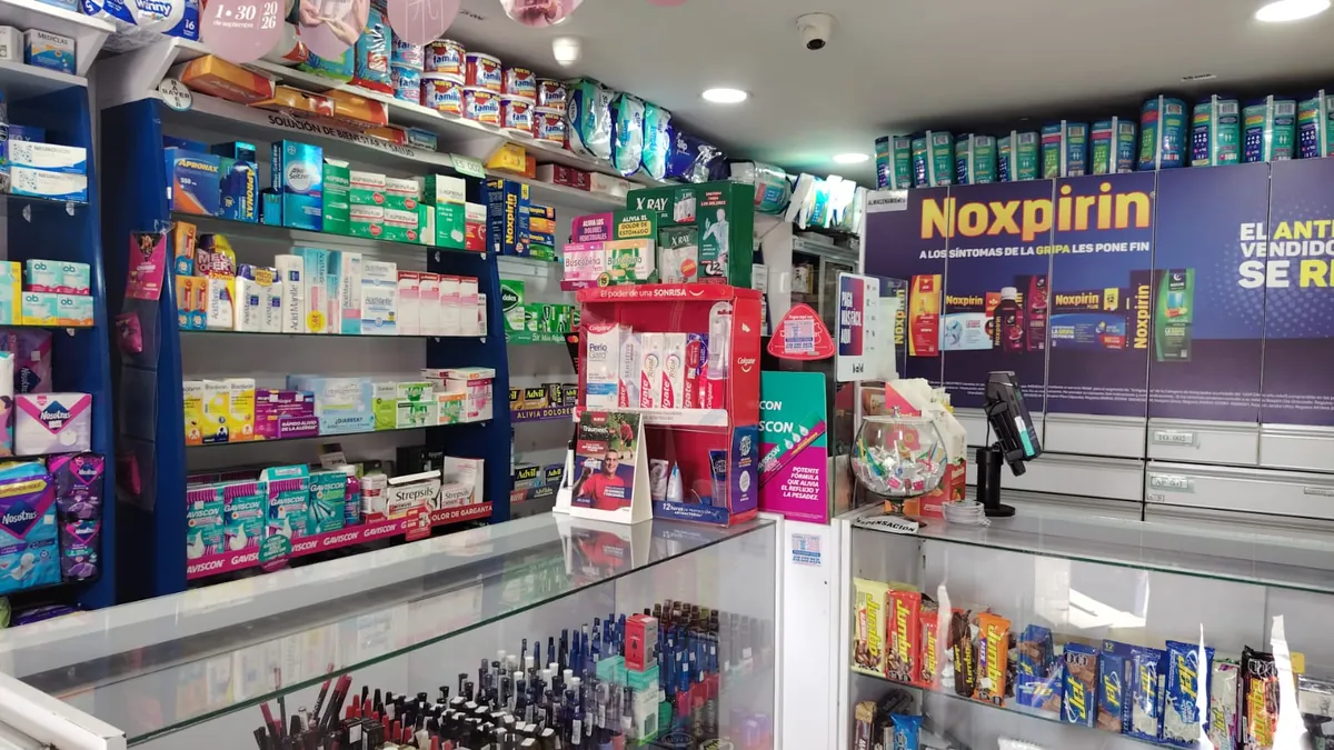 Anaqueles de la sede Villa del Prado con medicamentos y productos de cuidado personal, vistos desde el mostrador
