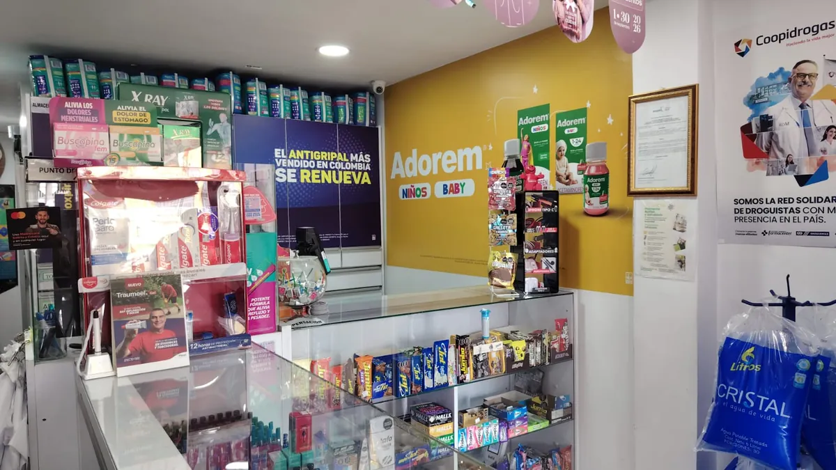 Interior de la sede Villa del Prado: vitrina de vidrio del mostrador y pared amarilla con productos para bebés y niños